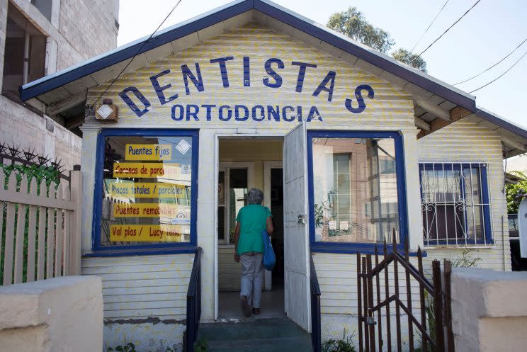 A woman enters a dentists’ office in Tijuana, Mexico. Data from a U.S. government survey suggests that 150,000 to 320,000 Americans list health care as a reason for traveling abroad each year. (Photo: Guillermo Arias/Bloomberg via Getty Images)