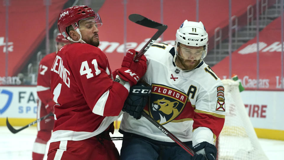 Detroit Red Wings center Luke Glendening (41) checks Florida Panthers left wing Jonathan Huberdeau (11) in the first period of an NHL hockey game Sunday, Jan. 31, 2021, in Detroit. (AP Photo/Paul Sancya)