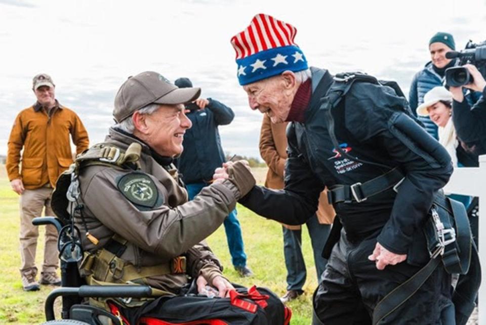 Gov. Greg Abbott shakes hands with 106-year-old World War II veteran Al Blaschke in San Marcos on Nov.27, 2023. The governor skydived for his first time with Blaschke, who holds the the Guinness World Record for the world's oldest tandem parachute jump.
