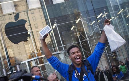 One of the first customers to purchase the Apple iPhone 5S celebrates after exiting the Apple Retail Store on Fifth Avenue in Manhattan, New York September 20, 2013. Apple Inc's newest smartphone models hit stores on Friday in many countries across the world, REUTERS/Adrees Latif