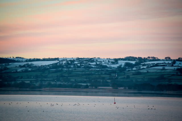 The sun rises over frost on fields at Chew Valley, Somerset (Ben Birchall/PA)