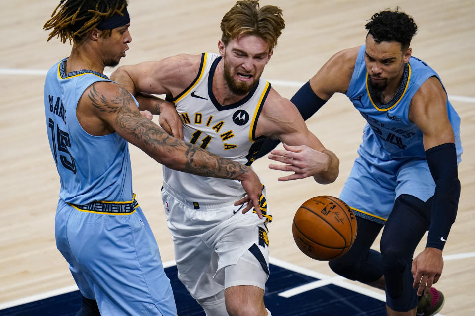 Indiana Pacers forward Domantas Sabonis (11) is fouled as he drives between Memphis Grizzlies forward Brandon Clarke (15) and guard Dillon Brooks (24) during the second half of an NBA basketball game in Indianapolis, Tuesday, Feb. 2, 2021. (AP Photo/Michael Conroy)