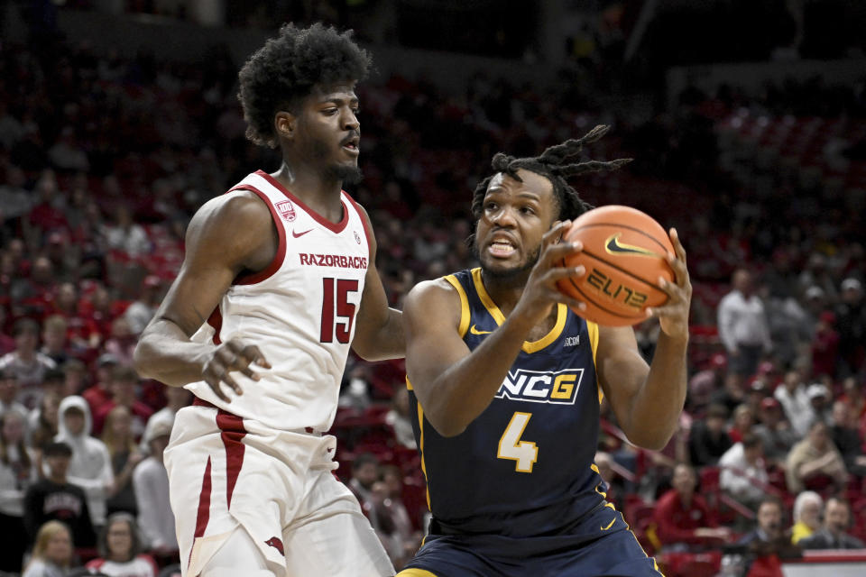 UNC Greensboro forward Mohammed Abdulsalam (4) tries to drive past Arkansas forward Makhi Mitchell (15) during the first half of an NCAA college basketball game Tuesday, Dec. 6, 2022, in Fayetteville, Ark. (AP Photo/Michael Woods)