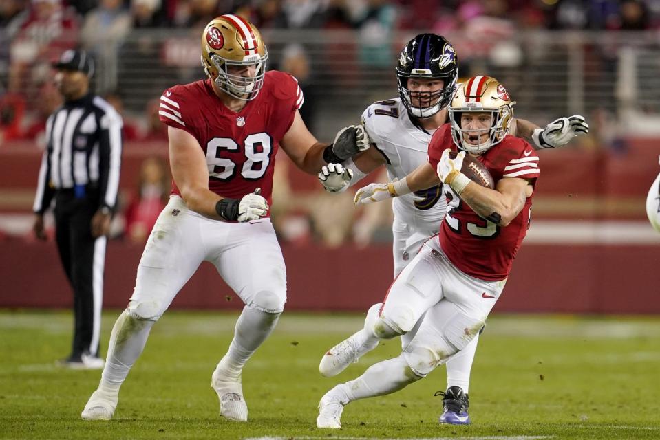 Dec 25, 2023; Santa Clara, California, USA; San Francisco 49ers running back Christian McCaffrey (23) runs the ball in front of offensive tackle Colton McKivitz (68) and Baltimore Ravens defensive end Brent Urban (97) in the second quarter at Levi's Stadium. Mandatory Credit: Cary Edmondson-USA TODAY Sports