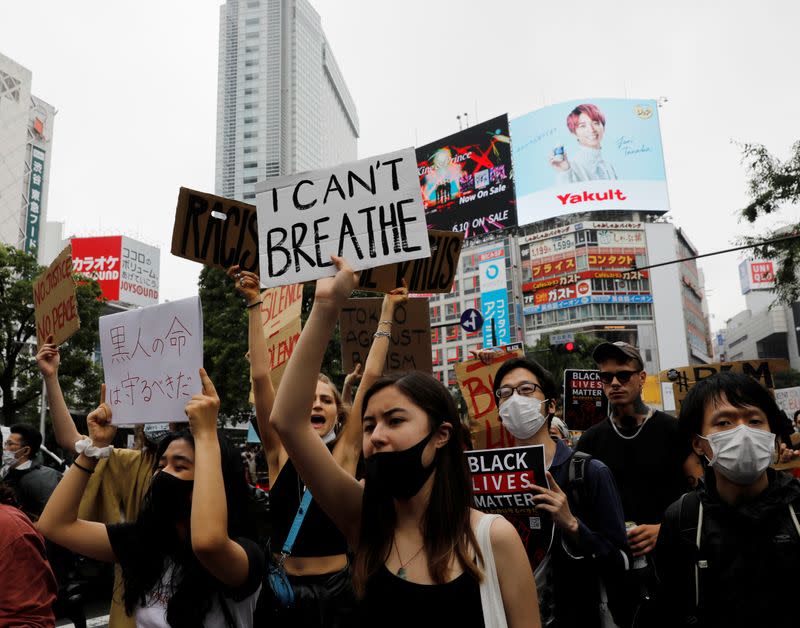 People wearing face masks march during a Black Lives Matter protest following the death in Minneapolis police custody of George Floyd, in Tokyo