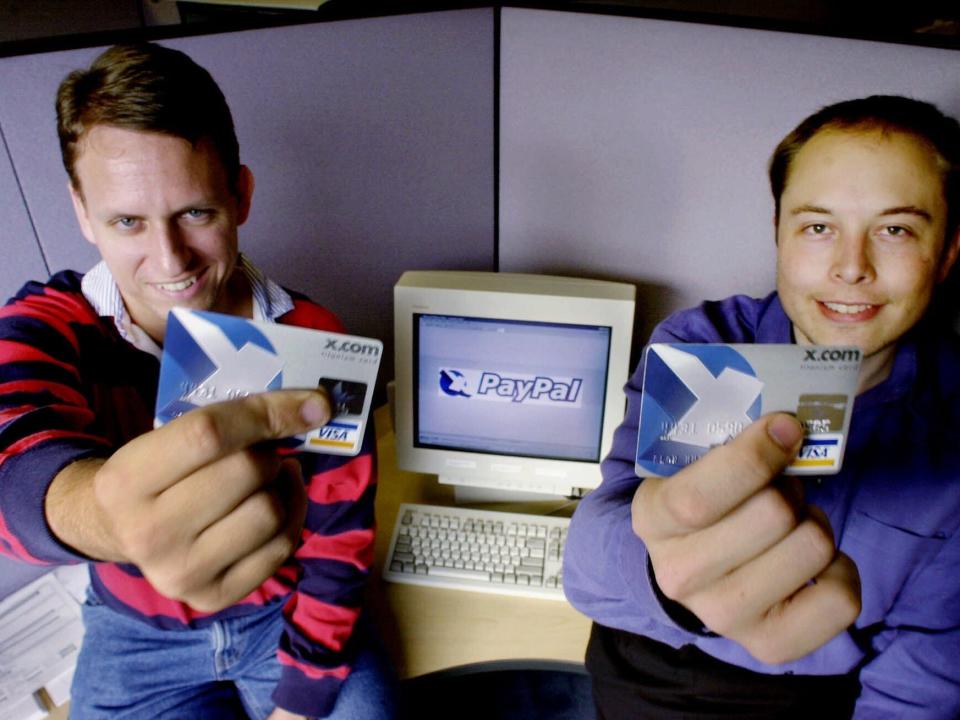 Peter Thiel and Elon Musk holding Visa credit cards