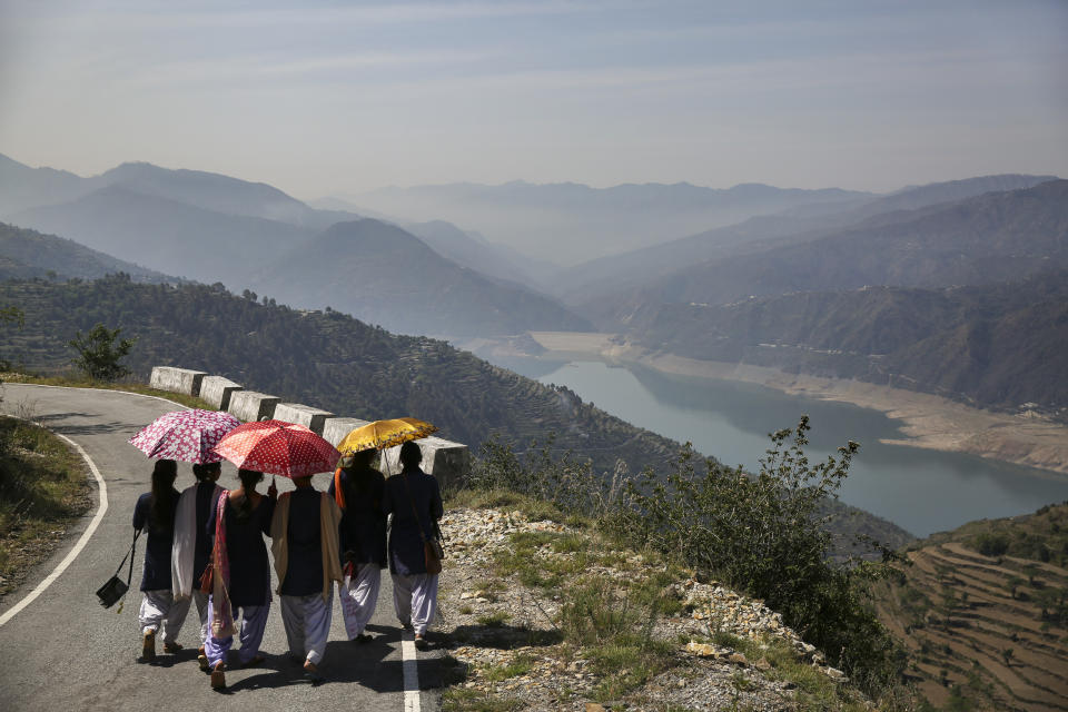 School girls walk along a road overlooking Tehri Dam in the northern Indian state of Uttarakhand, Monday, May 13, 2019. The Tehri Dam built on the Bhagirathi river is India's highest dam and supplies power and water to numerous Indian towns and cities. The Bhagirathi river is one of the two sources that form the River Ganges, the other being the river Alaknanda. (AP Photo/Altaf Qadri)