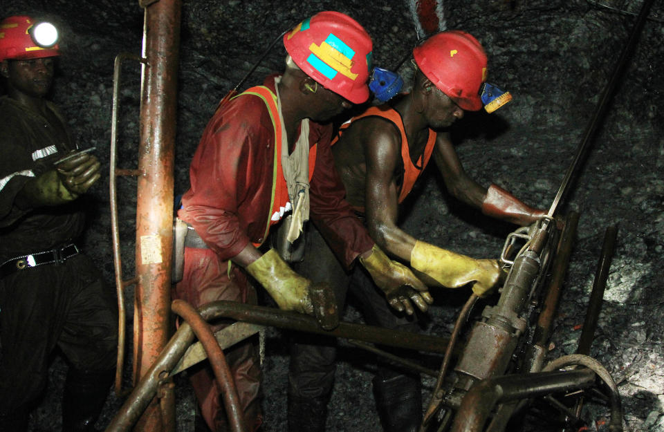 In this photo taken Thursday, Feb. 20, 2014, miners are photographed underground during a journalist's tour to the South Deep gold mine south of Johannesburg. Miners work some 2.4 kilometers (1.5 miles) underground in 12-hour shifts, where safety is a constant concern and everyone depends on everyone else to stick to precautions. (AP Photo/Themba Hadebe)