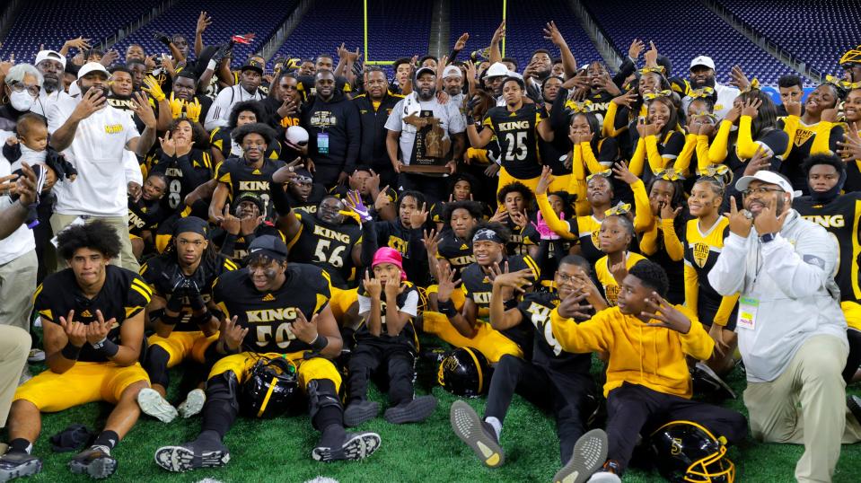 Detroit King coaches and players celebrate after winning the Michigan High School Athletic Association Division 3 final against DeWitt, 25-21, at Ford Field in Detroit on Saturday, Nov, 27, 2021.