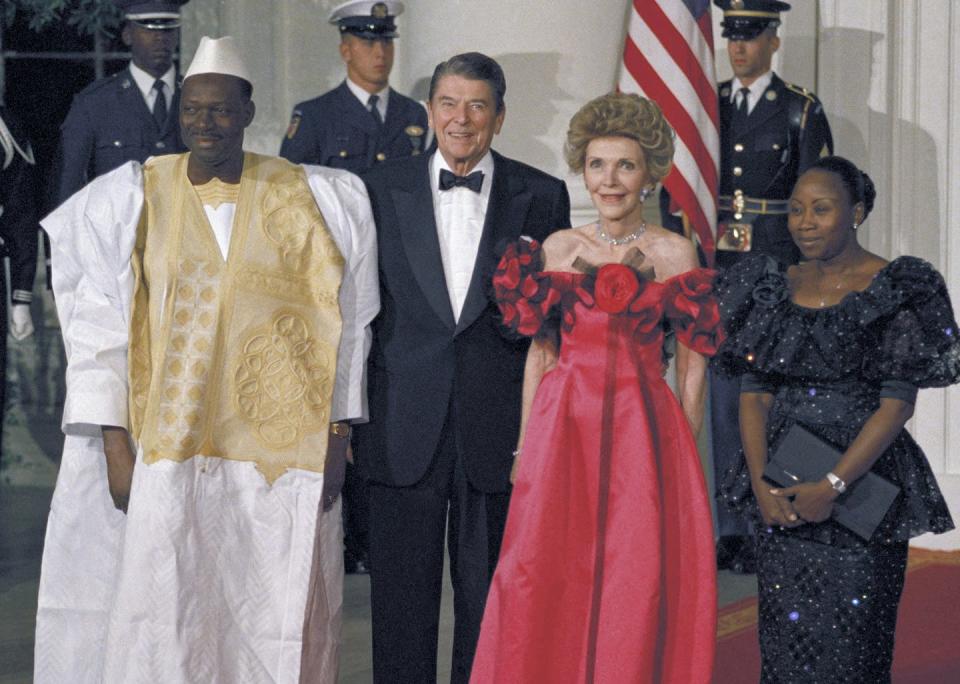 An African leader stands next to Ronald Reagan and their wives.