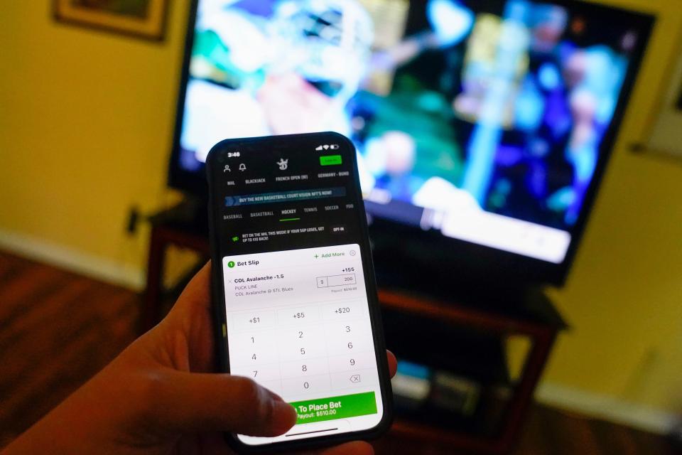 Photo illustration of the Draft Kings app on an iPhone.