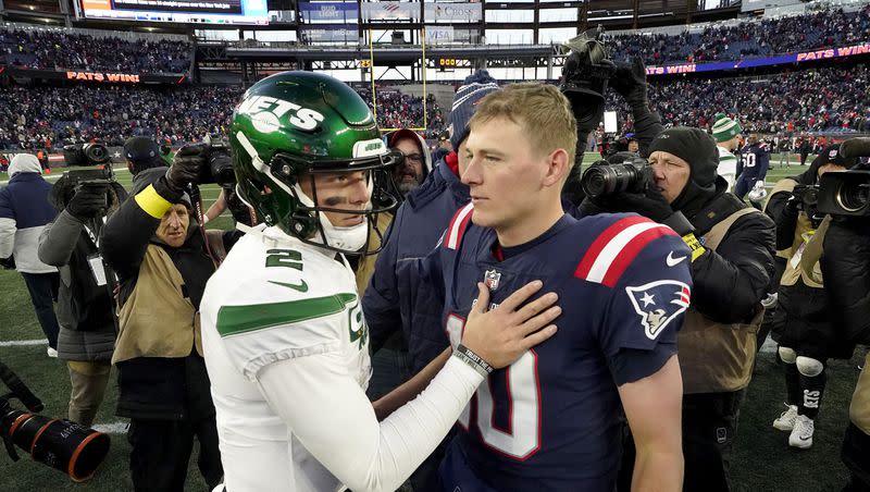 New York Jets quarterback Zach Wilson, left, greets New England Patriots quarterback Mac Jones, right, on the field following a game, Sunday, Nov. 20, 2022, in Foxborough, Mass.