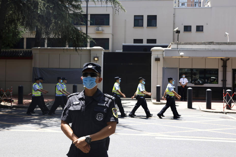 Chinese policemen march past the former United States Consulate in Chengdu in southwest China's Sichuan province on Monday, July 27, 2020. Chinese authorities took control of the former U.S. consulate in the southwestern Chinese city on Monday after it was ordered closed amid rising tensions between the global powers. (AP Photo/Ng Han Guan)