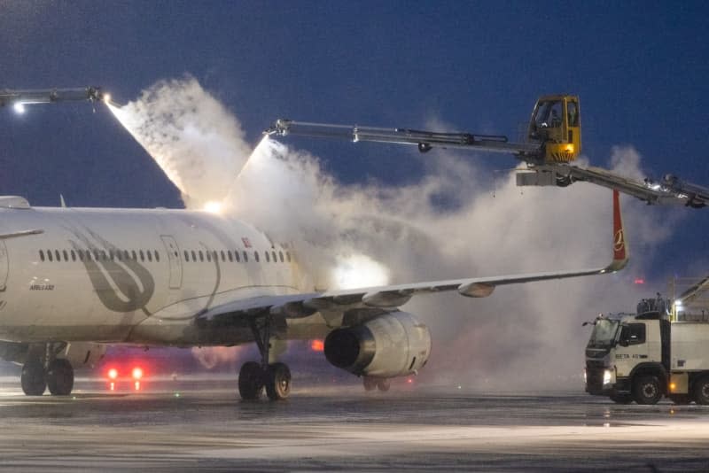 Turkish Airlines' plane is de-iced at Frankfurt Airport after many flights were canceled due to bad weather conditions. Lando Hass/dpa