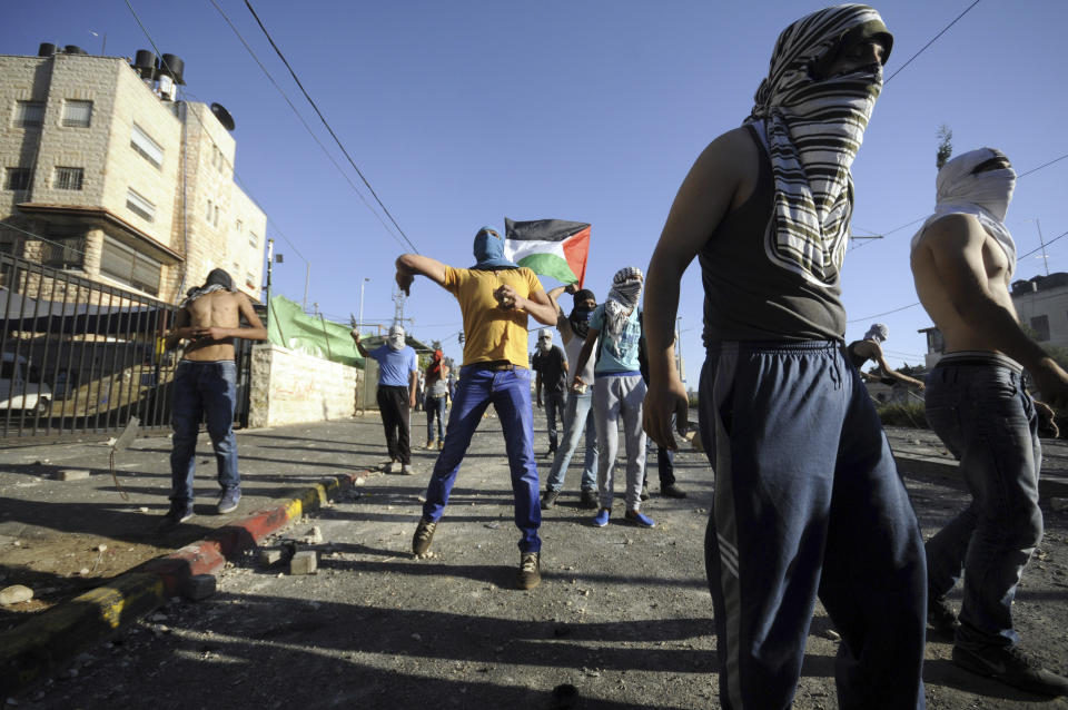 FILE - In this July 3, 2014 file photo, Palestinians throw stones during clashes with Israeli security forces after a 16-year-old Palestinian Mohammed Abu Khdeir was abducted and a charred body, believed to be the boy, was found in a Jerusalem forest. HBO's new docudrama series, “Our Boys,” co-created by Palestinian and Israeli filmmakers, about the killings of four Israeli and Palestinian teenagers, which set off a cascade of events leading to the 2014 Gaza war, is set to air next week and is likely to reopen wounds on both sides of the conflict. (AP Photo/Mahmoud Illean, File)