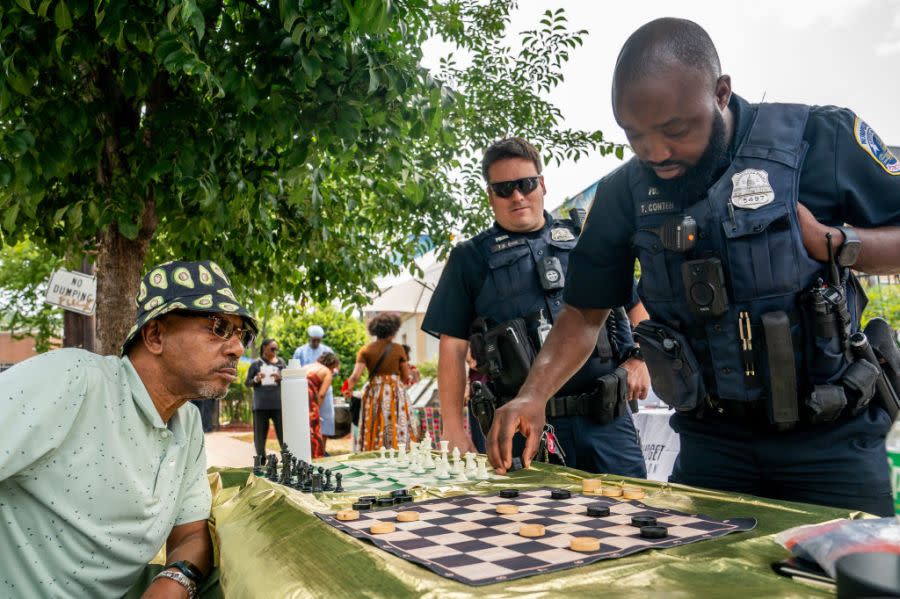 Metropolitan Police Officer Thomas Conteh (right) plays checkers against an attendee of a neighborhood Juneteenth festival on June 17 in Washington, D.C. (Photo credit: Nathan Howard/Getty Images)