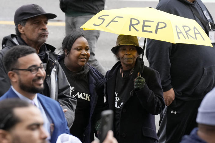 FILE - Pia Harris, with the San Francisco Housing Development Corporation, second from left, and her mother, Adrian Williams, listen to speakers at a reparations rally outside of City Hall in San Francisco, Tuesday, March 14, 2023. Harris hopes for reparations in her lifetime. But the nonprofit program director is not confident that California lawmakers will turn the recommendations of a first-in-the-nation task force into concrete legislation, given the pushback from opponents who say slavery was a thing of the past. (AP Photo/Jeff Chiu, File)