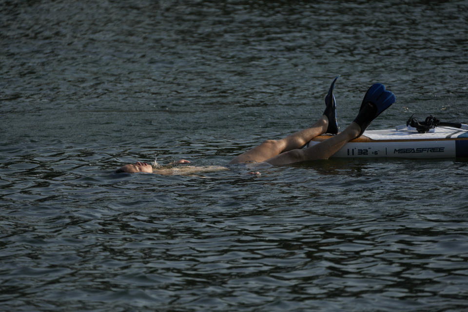 A man swims in the lake to cool off from an unseasonably hot day in Beijing, Sunday, June 16, 2024. China is being buffeted by two weather extremes, with heavy rain and flooding in parts of the south and a heat wave and potential drought in the north. (AP Photo/Andy Wong)