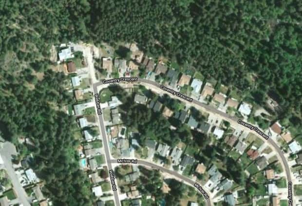 RCMP say a suspect was arrested after someone tried to start a fire on the wooded hillside near these homes in West Kelowna on Saturday evening.  (Google Maps - image credit)