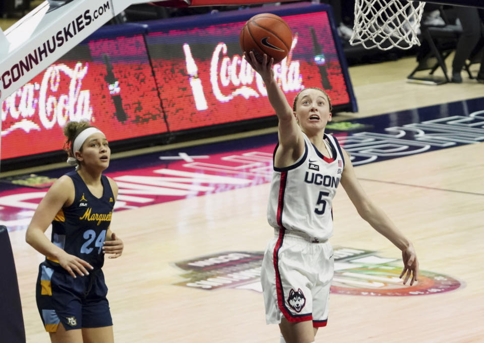 Connecticut guard Paige Bueckers (5) drives to the basket against Marquette guard Selena Lott (24) in the first quarter of an NCAA college basketball game Monday, March 1, 2021, in Storrs, Conn. (David Butler II/Pool Photo via AP)