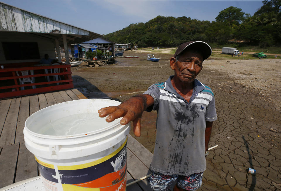 Raimundo Silva do Carmo, de 67 años, muestra el agua que sacó de un pozo en el lecho seco del lago Puraquequara, el jueves 5 de octubre de 2023, en Manaos, estado de Amazonas, Brasil. (AP Foto/Edmar Barros)