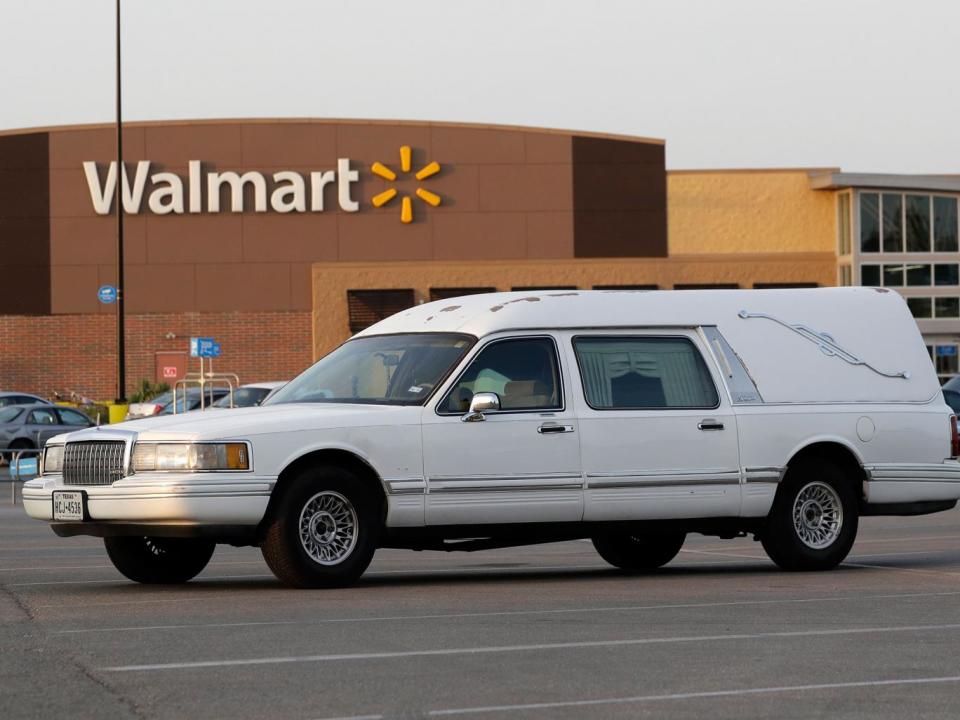 A hearse sits in the car park of a Walmart supermarket in San Antonio, where eight people were found dead in a tractor-trailer loaded with at least 30 others on 23 July (AP)