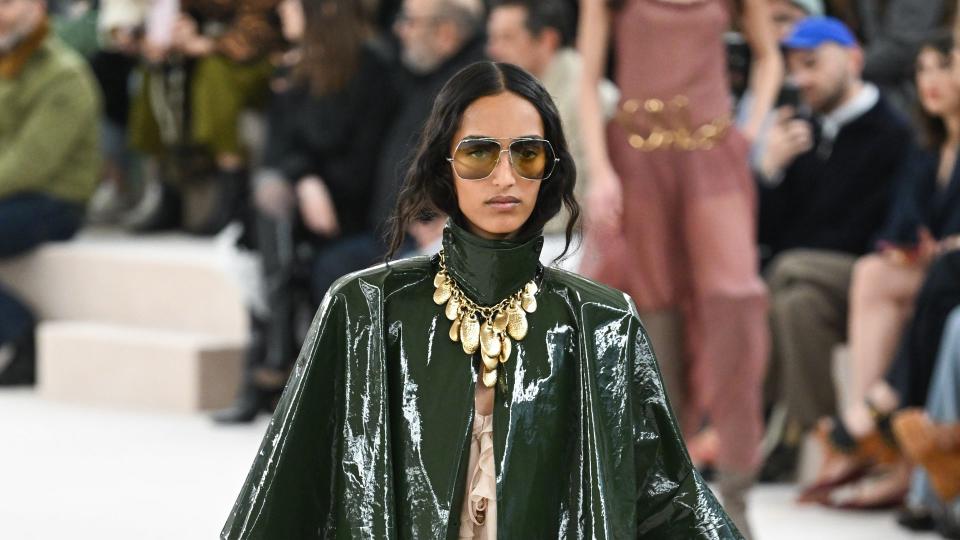 A model walks the runway during the Chloé Womenswear show in a patent green trench coat