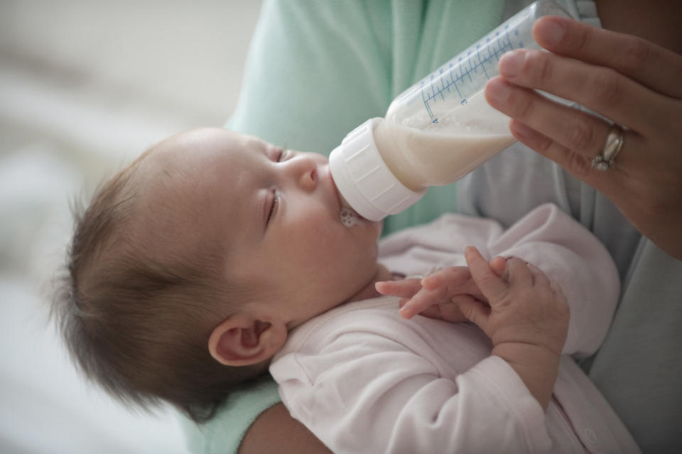 A parent feeding their baby with a bottle