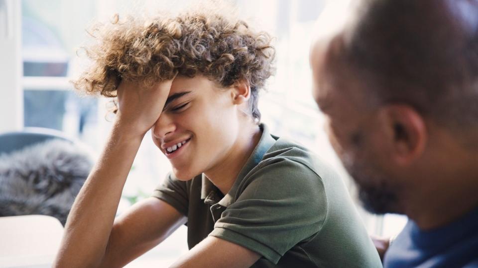 Teenager laughing or cringing at parent