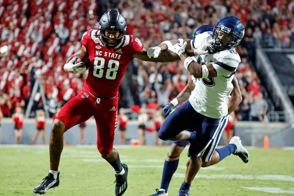 North Carolina State’s Devin Carter (88) stiff-arms Connecticut’s Chris Shearin (10) following a reception during the first half of an NCAA college football game in Raleigh, N.C., Saturday, Sept. 24, 2022.