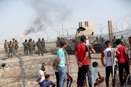 Iraqi security forces stand guard inside the west Qurna 2 oilfield, during a protest in north Basra, Iraq July 14, 2018. Picture taken July 14, 2018. REUTERS/Essam al-Sudani