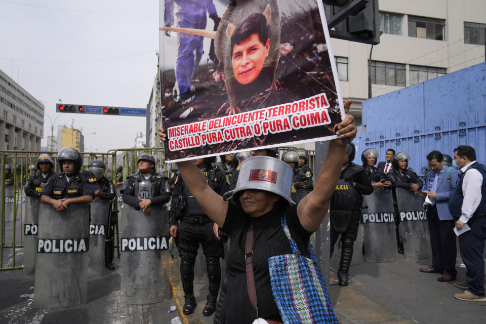 FILE - An opponent of Peruvian President Pedro Castillo holds a poster depicting Castillo as a rat with a message that reads in Spanish: "Miserable delinquent, terrorist," during a rally near Congress in Lima, Peru, Wednesday, Dec. 7, 2022. Peru's Congress voted to remove Castillo from office Wednesday and replace him with the vice president, shortly after Castillo tried to dissolve the legislature ahead of a scheduled vote to remove him. (AP Photo/Martin Mejia, File)