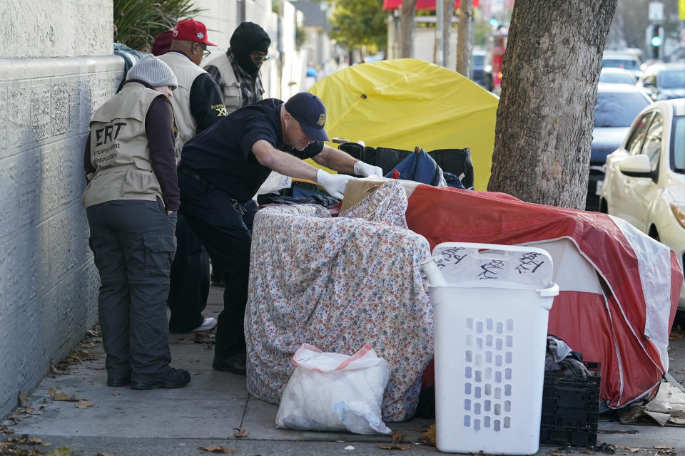 FILE - Members of the San Francisco Homeless Outreach Team's Encampment Resolution Team make contact with homeless people in San Francisco, on Dec. 13, 2022. Lawyers for San Francisco argued in appellate court Wednesday, Aug. 23, 2023, that workers can no longer maintain safe, clean streets while getting homeless people the help they need after a federal judge banned the city from clearing homeless encampments. Similar tensions are playing out in other U.S. western cities grappling with growing encampments. (AP Photo/Godofredo A. Vásquez, File)