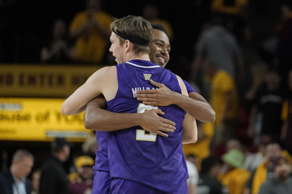 Washington guard Anthony Holland (23), right, gives a hug to Washington guard Paul Mulcahy (9) after their 84-82 overtime win against Arizona State during an NCAA college basketball game Thursday, Feb. 22, 2024, in Tempe, Ariz. (AP Photo/Darryl Webb)