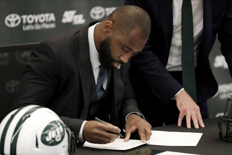 Former New York Jets cornerback Darrelle Revis signs a one-day contract with the Jets during a news conference officially announcing his retirement from NFL football, Tuesday, July 24, 2018, in Florham Park, N.J. Revis leaves behind an 11-season career that included four All-Pro selections and a Super Bowl win with the New England Patriots. (AP Photo/Julio Cortez)