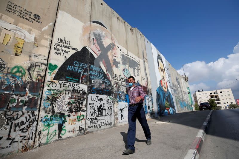 A Palestinian man walks past an anti-U.S. President Donald Trump mural which was painted on a section of the Israeli barrier, in Bethlehem in the Israeli-occupied West Bank