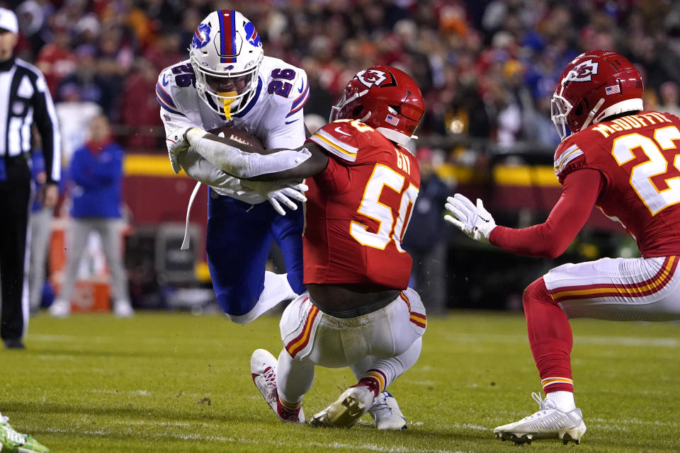 Buffalo Bills running back Ty Johnson (26) runs with the ball as Kansas City Chiefs linebacker Willie Gay (50) and cornerback Trent McDuffie, right, defend during the second half of an NFL football game Sunday, Dec. 10, 2023, in Kansas City, Mo. (AP Photo/Ed Zurga)