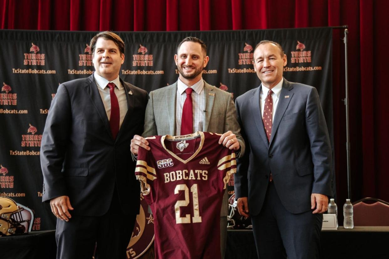 New Texas State head football coach G.J. Kinne, center, stands next to Bobcats athletic director Don Coryell, left, and Texas State President Kelly Damphousse during Kinne's introductory press conference Wednesday in San Marcos on Dec. 7, 2022.