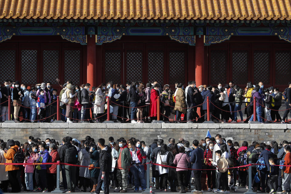Visitors wearing face masks to help curb the spread of the coronavirus line up to enter an exhibition held at the Forbidden City in Beijing, Saturday, Nov. 7, 2020. China on Saturday reported over a two dozen new confirmed coronavirus infections, all of which the National Health Commission said were in patients who contracted the virus abroad. (AP Photo/Andy Wong)