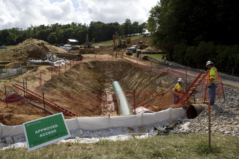 FILE - In this June 22, 2018, file photo, construction crews bore beneath U.S. 221 in Roanoke County, Va., to make a tunnel through which the Mountain Valley Pipeline will pass under the highway. The Trump administration is seeking to fast track environmental reviews of the pipeline and dozens of other energy, highway and other infrastructure projects across the U.S. (Heather Rousseau/The Roanoke Times via AP, File)