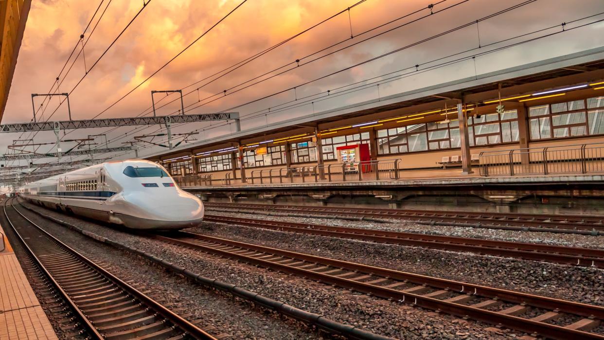 Japanese bullet train leaving station at dawn