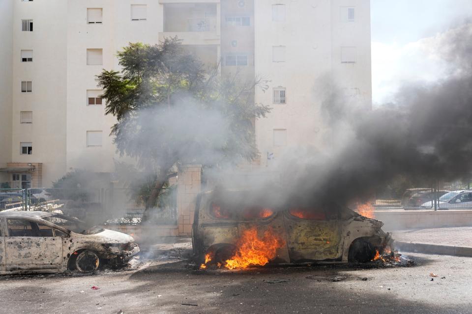 Cars are on fire after they were hit by rockets from the Gaza Strip in Ashkelon, Israel, on Saturday, Oct. 7, 2023. Palestinian militants in the Gaza Strip infiltrated Saturday into southern Israel and fired thousands of rockets into the country while Israel began striking targets in Gaza in response.