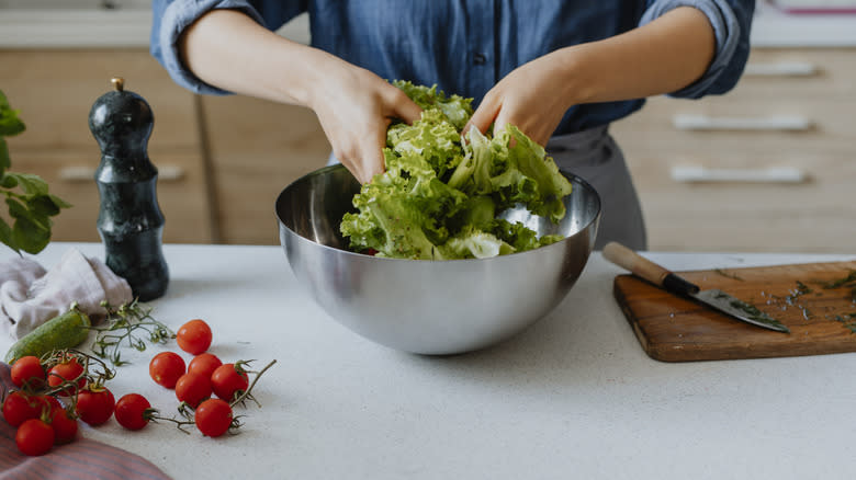 woman tossing salad by hand