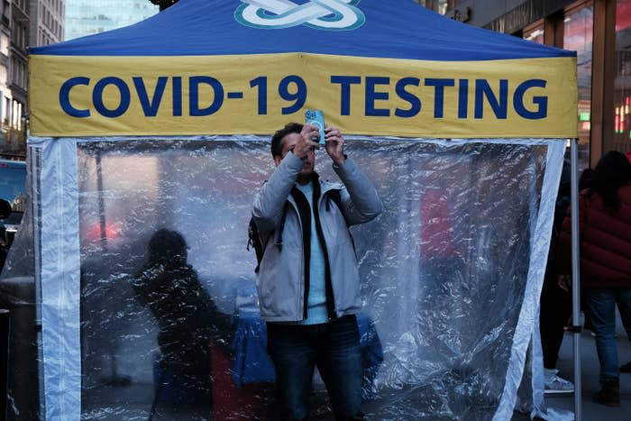 A man takes a selfie in front of a COVID testing site in Midtown Manhattan on Dec. 9, 2022. 