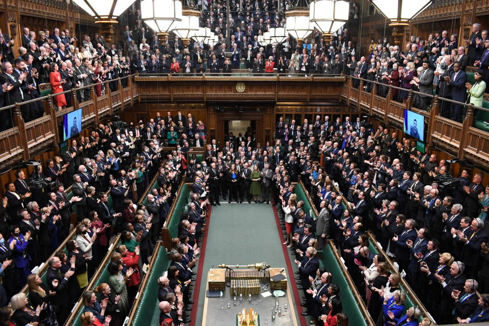 In this photo provided by UK Parliament, Ukrainian President Volodymyr Zelenskyy is displayed on the screen as he addresses British lawmakers in the House of Commons in London, Thursday March 8, 2022. Speaking by video link, the Ukrainian leader urged the U.K. to increase sanctions on Russia, to recognize Russia as “a terrorist country” and to keep Ukraine’s skies safe. He was given a standing ovation by members from all parties in the House of Commons. (Jessica Taylor/UK Parliament via AP)