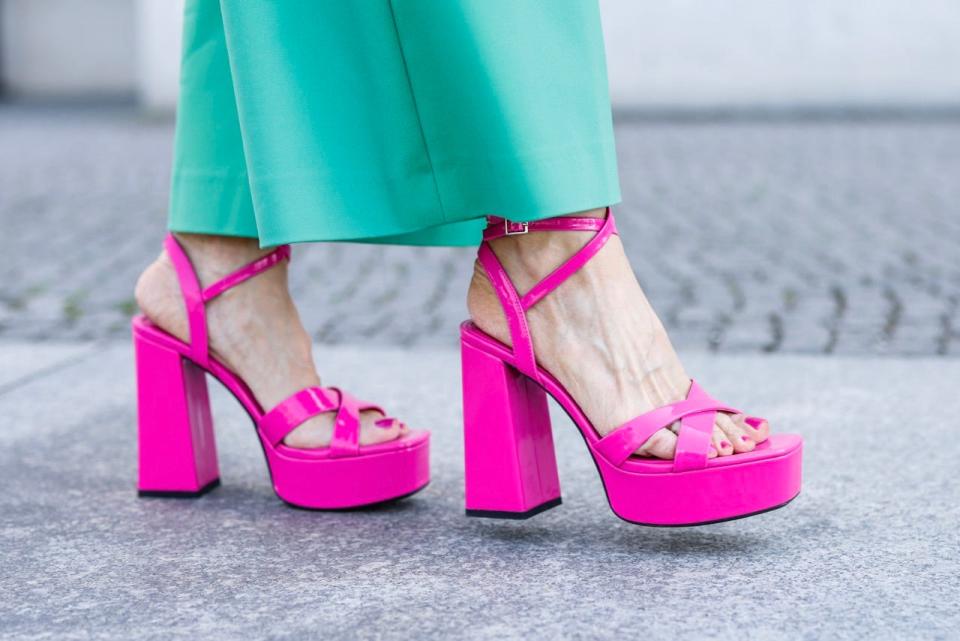 Bright pink chunky platform heels with green pants