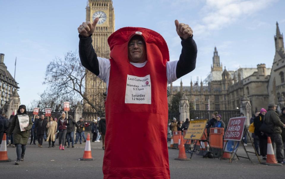 One of the postal workers who gathered for a rally in central London on Friday - Anadolu Agency/Getty Images