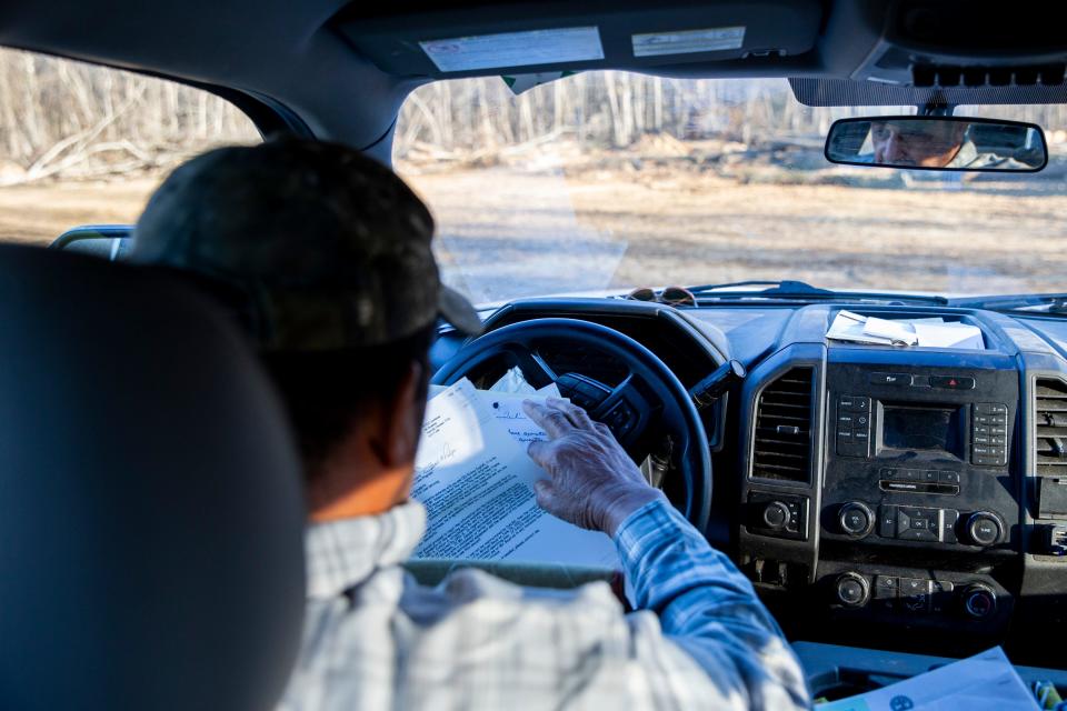 Marvin Sanderlin, a multi-generational farmer, looks through the paperwork he will be submitting to the Disadvantaged Farmers Assistance Program while sitting in his truck at the site where he gathers lumber in Stanton, Tenn., on Thursday, Dec. 7, 2023.
