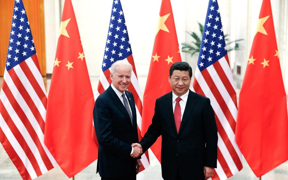 Chinese President Xi Jinping shakes hands with then US Vice President Joe Biden in 2013 - AFP