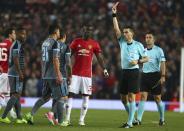 <p>Romanian referee Ovidiu Hategan (R) shows a red card to Manchester United’s Eric Bailly (C), after a clash with Celta Vigo players at Old Trafford stadium in Manchester, north-west England, on May 11, 2017 </p>